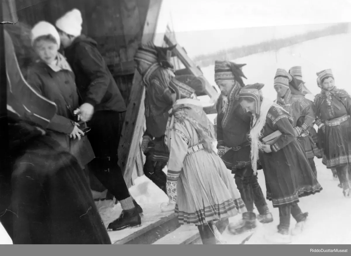 Mielvázzit vázzet girkui.
Brudefølge går inni kirken.

Adjo-Juhana Garen Anne, Anta- Juhana Ante,