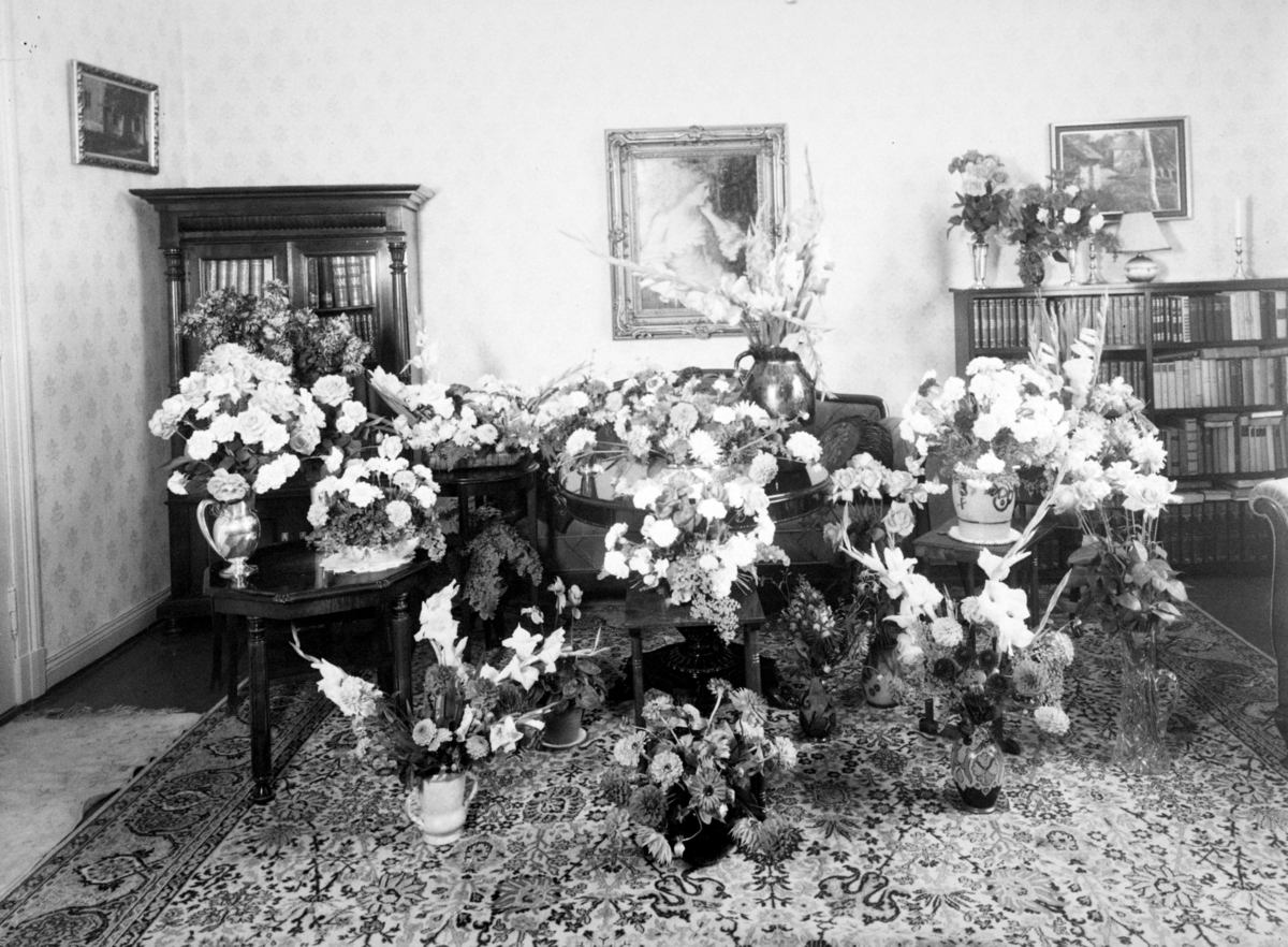 Stueinteriør med mange blomsterbuketter. Fra protokollen: "Frk. Olsen. Skipsmegler Olsen."
Skipsmegler M O Olsen, kontor i Storgata 12 og bolig i "Hassing. 2".