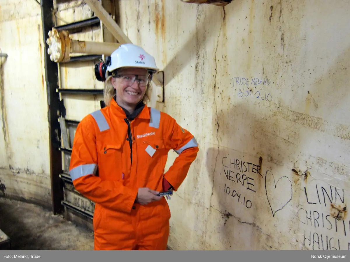 Trude Meland fra Norsk Oljemuseum skriver sin signatur i   nederst i utstyrsskaftet  på havets bunn - Statfjord A.