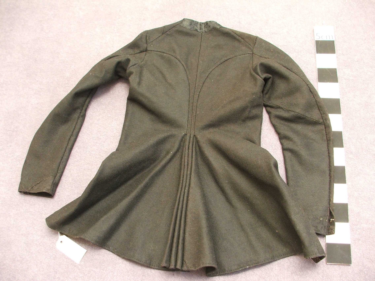 Svart blomstra silkeaktig band på
kragen. Rette og bølgeforma prydsaum på kvar side av opningen framme.