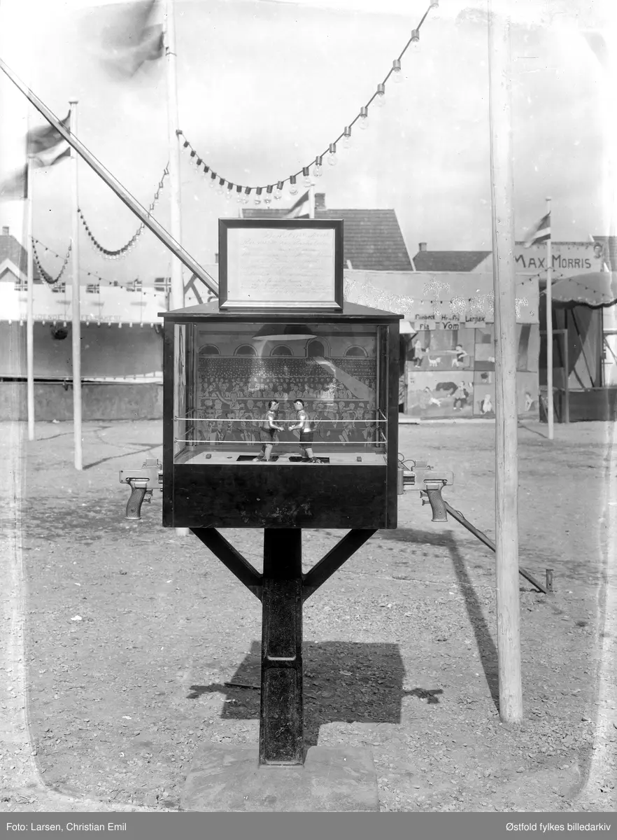 Østfoldutstillingen i Sarpsborg 1930. Boksespill, spillautomat, to bokser-figurer i fornøyelsesavdelingen utendørs (tivoli). Til høyre skimtes inngangspartiet til Max Morris.
Østfold fylkesutstilling i samarbeid med Sarpsborg kommune og Østfold landbruksselskap (100 år) og de andre Østfoldbyene. 
I alt ti avdelinger for skogbruk, landbruk, industri, husflid, osv. Også kulturhistorisk utstilling på Borgarsyssel Museum.