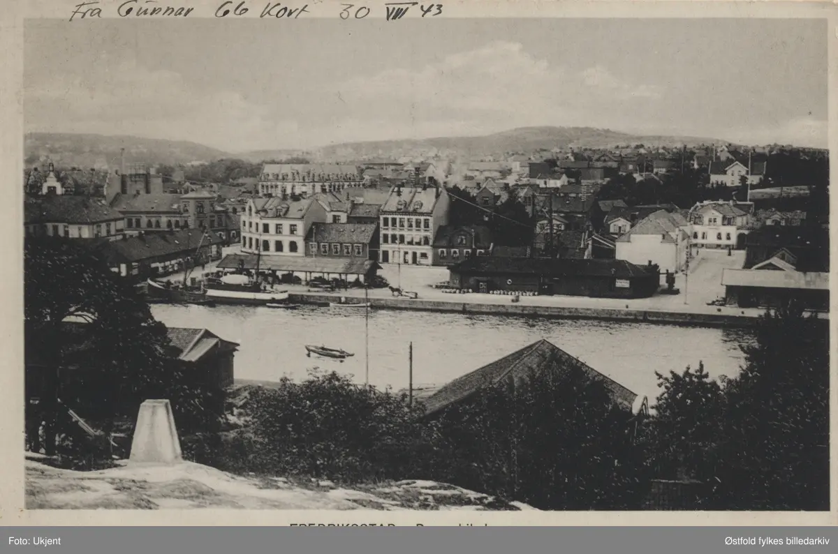 Oversiktsbilde tatt fra Kråkerøy mot Dampskipsbrygga i Fredrikstad på Vestsiden av elva. Postkort.

Dette bilde er tatt i 1902 - 1903 Fra Damskibsbrygga som også ble kalt Høytorvet, da det ble brukt av bøndene på lørdager til å selge høy,. når det så regnet ble høyet kjørt inn under halvtaket. (Aage Dedekam 2015).