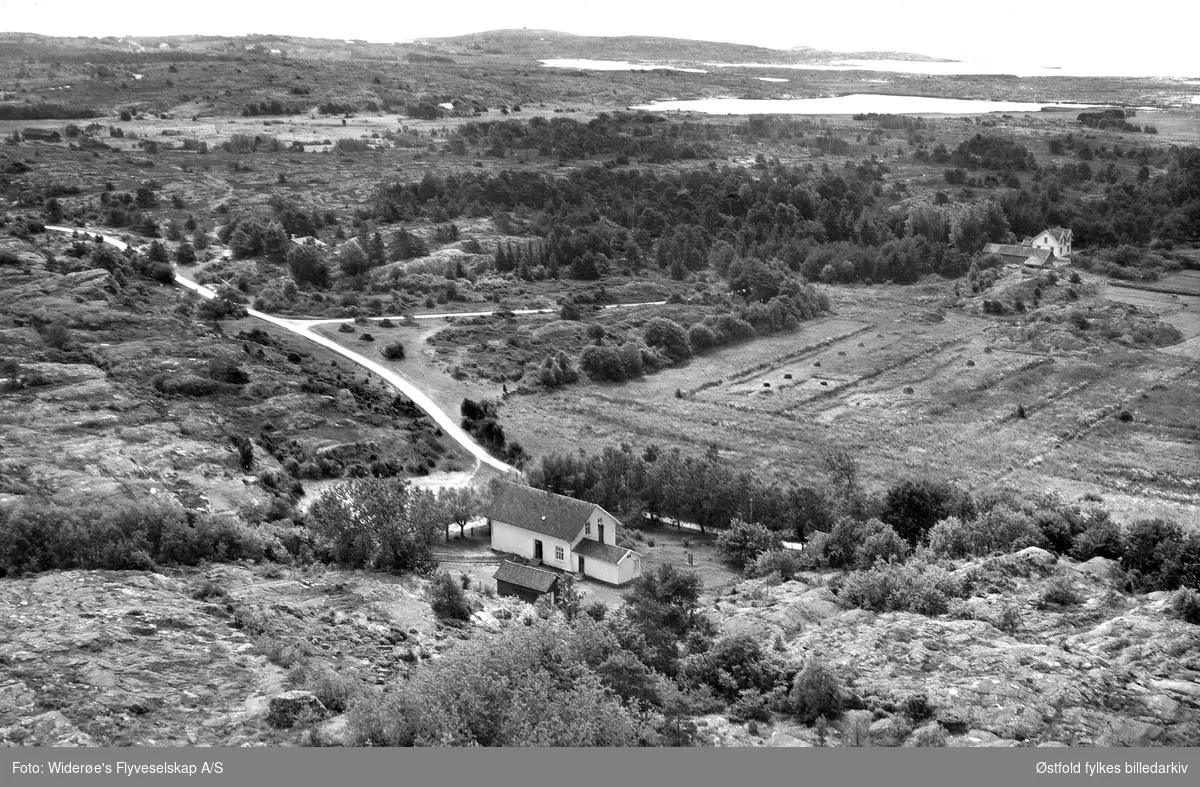 Gamle skolen  Asmaløy, Hvaler 1957. Skråfoto/flyfoto.

Stedet kalles Trekanten. Veien opp mot venstre kalles Skolebakken  (idag Gamle Skolevei) og huset i høyre kant av bildet tilhører familien Sørlie. Vikertangen i bakgrunn.