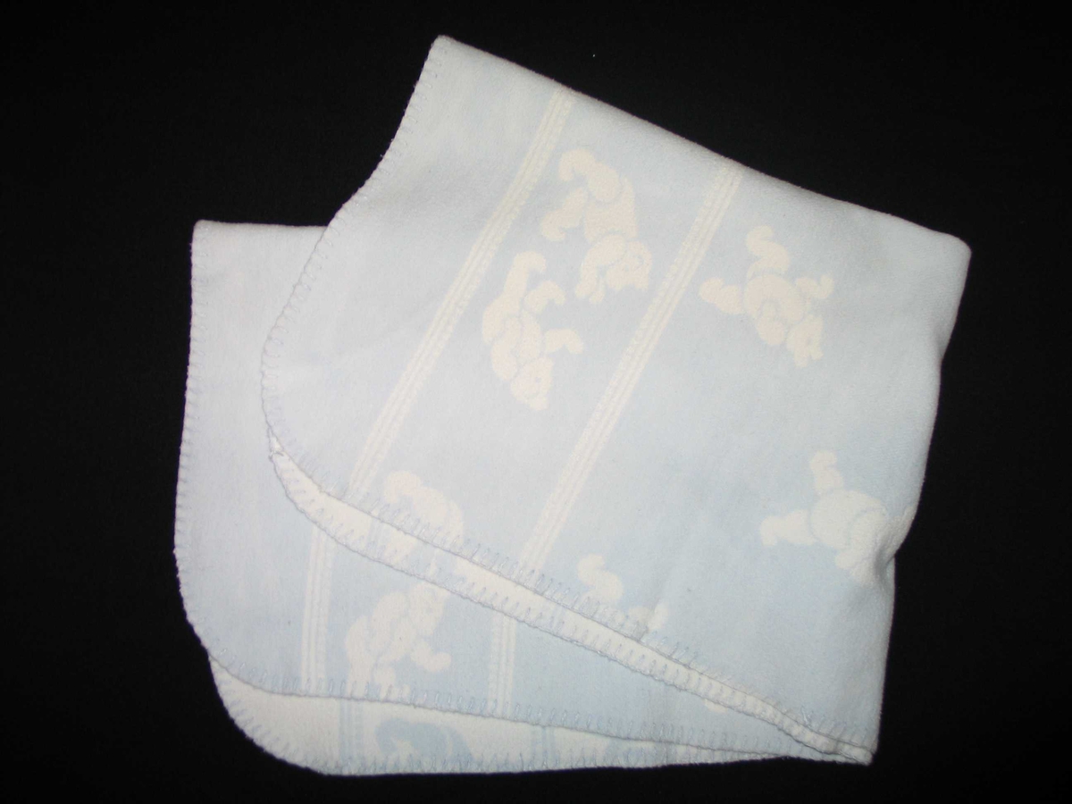 Teppet er kvitt på den eine og blått på den andre sida. På den blå sida er kvite bamsar, på den kvite sida er kvite bamsar.