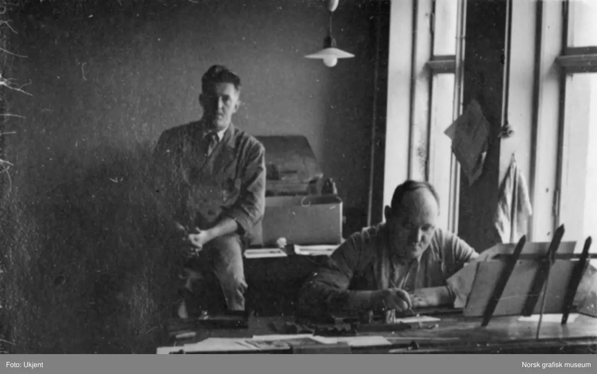 To menn i arbeidstøy avbildet ved en arbeidspult. Fra Dreyers Reproduktionsanstalt i Stavanger.
Albumtekst: Berge. Jansen.
