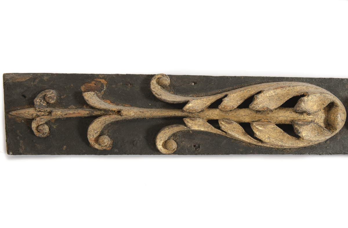 Pilaster till EUGENIES akterspegel. Skulpterade gulmålade blommor på underliggande förgyllning, monterade på plan av svartmålat trä.