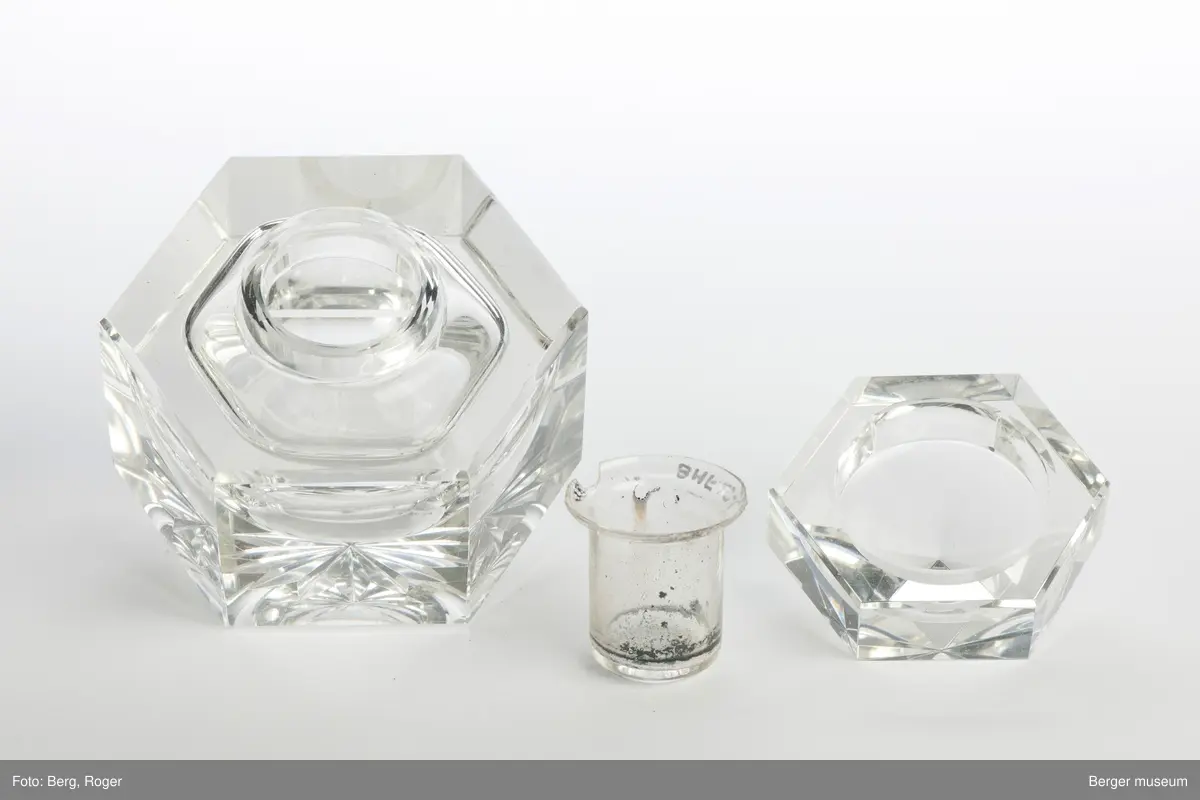 Blekkhus med lokk og en liten beholder til å ha blekk i. Objektet består derfor av tre deler. Stjernemønster under. Blekkhuset og lokket er 6-kantet.