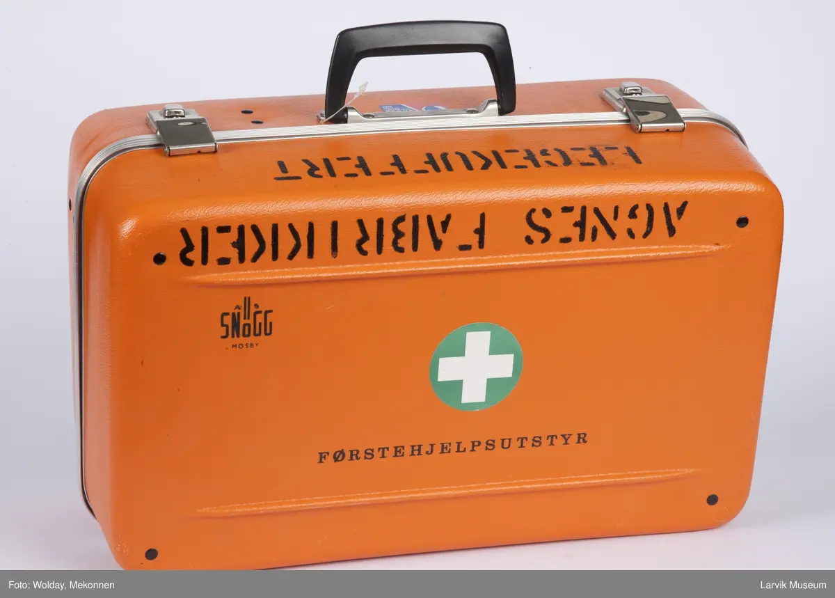Legekoffert med diverse utstyr som bandasje, plaster, gasbind, bomuld, diverse sakser, sprøyter etc., samt liste over innhold.

Førstehjelpskoffert koffert til bruk for lege som kommer tilstede ved ulykker i bedrift.

2 nøkler henger fast i håndtaket.