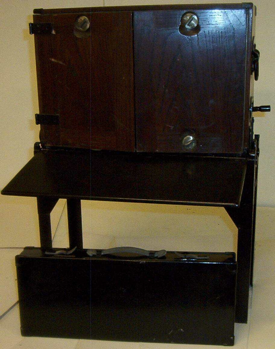 Telefonsentral (feltveksler) av eldre type med ledninger og plugger i grønn transportkasse på fire bein.