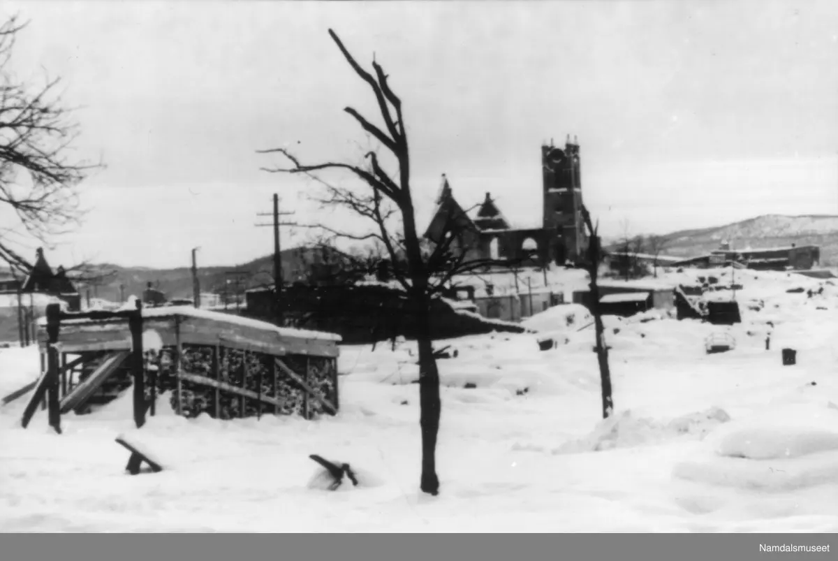 1940-45. Namsos sentr. m./kirken. Vinter, i forbgrunnen et vedlager.
