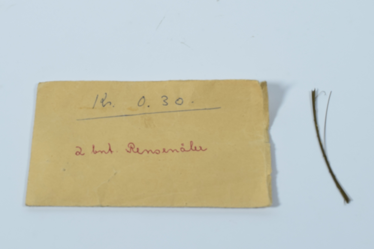 Oransje, rektangulær, plasteske uten lokk som inneholder diverse kanyler og sprøyter. 

Det er 22 kvadratiske, flate esker med kanyler i stål. 20 av eskene er av plast, hvorav 12 er i klar plast og 8 er i hvit plast med skyvelokk i klar plast. En eske er av metall og en er av papp. Antallet kanyler i eskene varierer og de er av forskjellig størrelse. Det er også tre mindre esker i plast med hvit lokk som inneholder 6 kanyler hver. En lang kanyle ligger løs.

Det er fire esker i hvit papp som inneholder hver sin sprøytesylinder uten stempel. Sprøytesylinderene er av plast. Tre er av ensartet størrelse (10cm lang eske), mens den fjerde er litt mindre (8 cm lang eske). En sprøytesylinder av glass med metallbeslag i begge endene ligger løs.

Den oransje esken inneholder også en brun papirkonvolutt med 11 bunter tynne metalltråder. På konvolutten står det "Rensenåler".