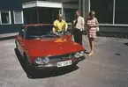 Två män och en kvinna vid en personbil, Lancia Fulvia, utanför Albin Marins lokaler i Kristinehamn.
