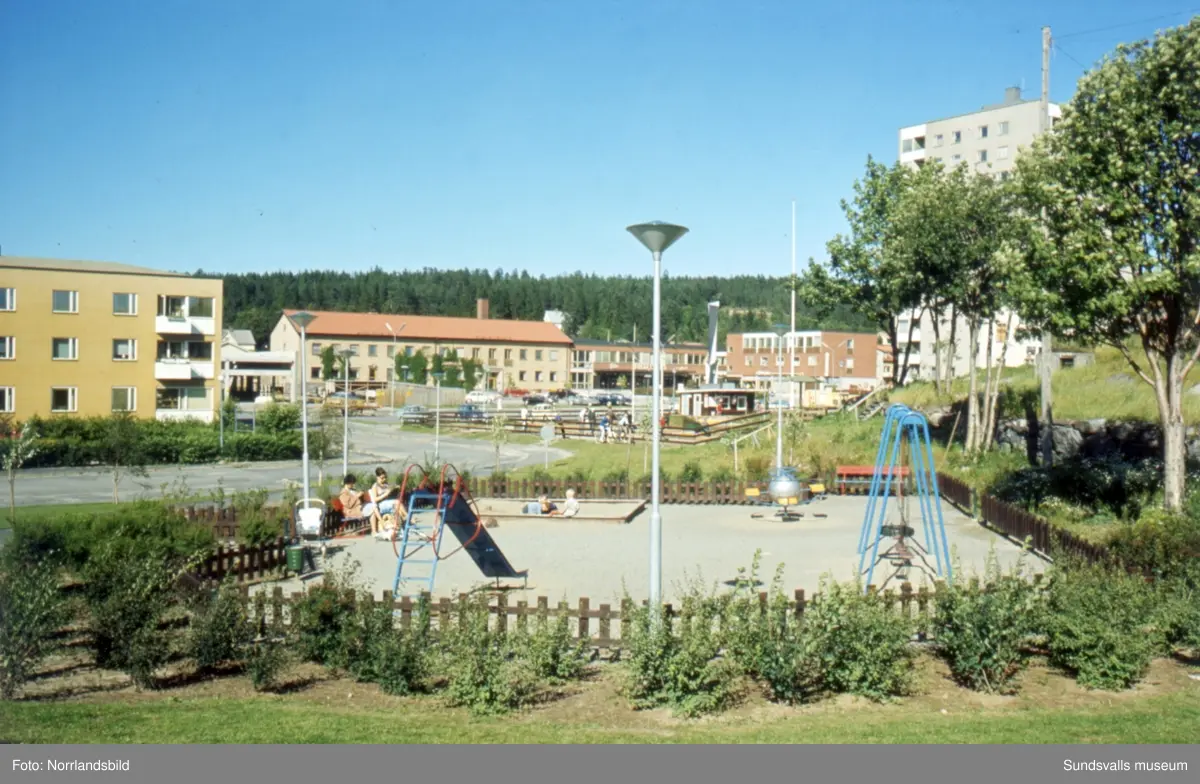 Centrala Skönsberg med höghuset, Folkets hus med skulpturen Spiral reflex, minigolfbana och lekpark.