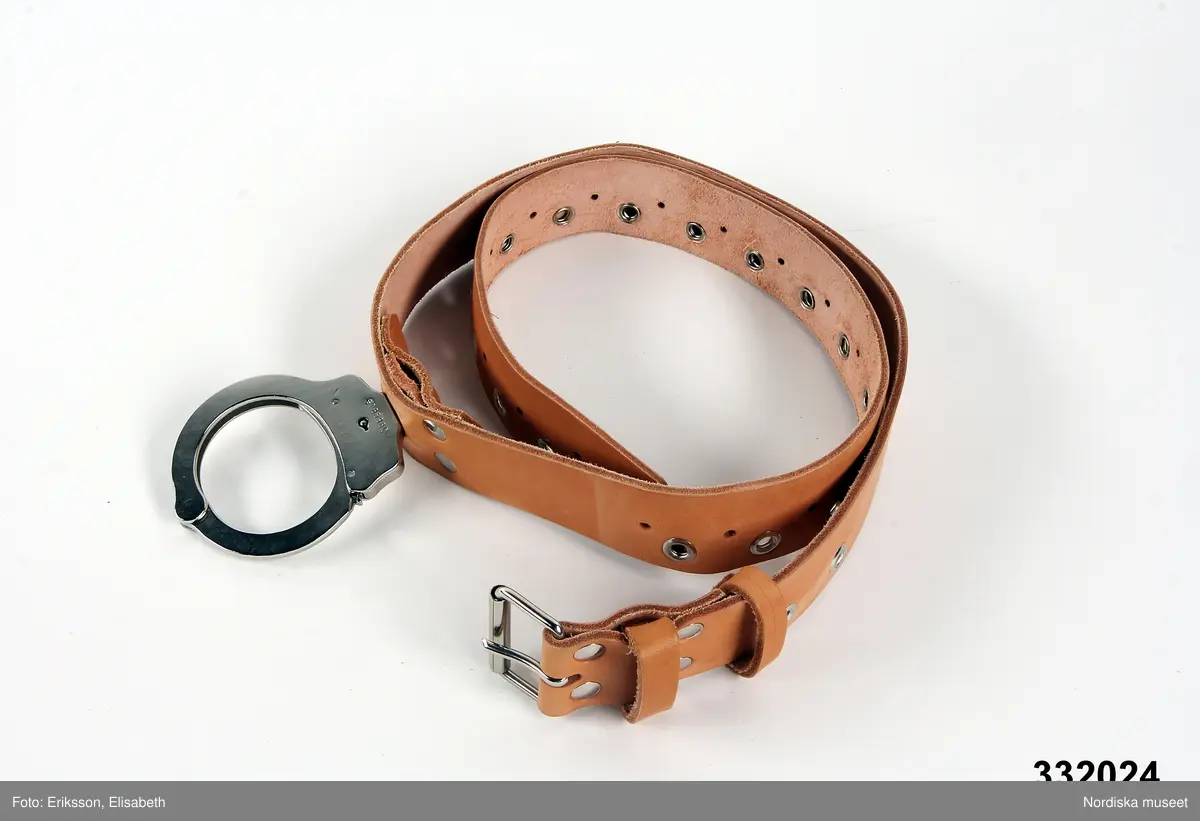 Skärp av skinn med en handboja av metall. Märkt med Kriminalstyrelsens nummer: N-111177. Anm: Oanvänt.
/Johanna Skoglund 2013-06-03