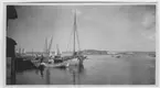 'Utsikt åt norr med Mansholmen. Båtar vid brygga. 3 män invid bryggan. ::  :: Serie fotonr 1888-1963.'