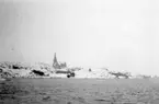 'Skagerrakexpeditionen 1933-03-06 - 1933-03-08: ::  :: Vy med Lysekil sett från norr, Flatholmsrännan i snö och dis. Vy med kyrka på avstånd. ::  :: Ingår i serie med fotonr. 2828-2838.'