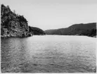 'Naturhistoriska muséets Skagerackexpedition med båten Skandia sommaren 1934: ::  :: Svinungsund, vy från havet in i sundet med berg på sidorna. Liten träbyggnad till vänster. ::  :: Ingår i serie med fotonr. 3309-3317.'