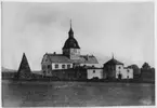 Vy med kyrkan i herresätet Östråt. Stenbyggnad med glasfönster. Till vänster om byggnaden hög stenpyramid. Se även fotonr. 3339.