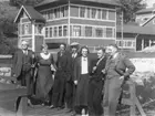 'Gruppbild tagen utanför Biologiska statationen, Trondheim, 7 personer varav 2 kvinnor och 5 män stående på brygga nedanför större trähus. Från vänster till höger: Leonard Axel Jägerskiöld, Fru Hanson, Dr Nils Odhner, Kapten Bewh Hanson, Fröken Fröseth?, fru Hansons nevö och längst till höger Sune Swärd. ::  :: Ingår i serie med fotonr. 3679-3693 se även 3694-3719.'