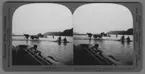 'Uppdragning av fiskenät med hjälp av hästar. Män och hästar i vattnet. I förgrunden del av eka. ::  :: ''6177 - Dragging in the Nets - Fishing on the Columbia river, Oregon, U.S.A.'' ::  :: Ingår i serie med fotonr. 315-422. Se särskilt fotonr. 404.'