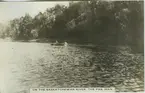 '''On the Saskatchewan river. The Pas. Man.'' 2 personer i en kanot, på avstånd. ::  :: Ingår i serie Fotonr. 5218:1-12. Se även hela fotonr. 5202-5218 med bilder från Frits Johansen.'