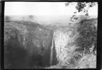 'Diverse fotografier från bl.a. dåvarande Nordrhodesia, nu Zambia, tagna av Konsul Magnus Leijer. ::  :: Vy över berg och skog med vattenfall, fotograferat från avstånd.'