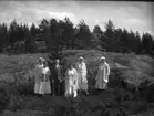 'Bildtext: ''Tibble 1917.'' :: Gruppbild på 4 kvinnor och 1 man. I bakgrunden berghällar och gran- och tallvegetation. ::  :: Ingår i serie med fotonr. 5231:1-11. Se även fotonr. 5223:1-13, 5232:1-8 och 5234:1-12.'