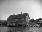 'Bildtext: ''Kyrkesund 1927.'' :: Vy med större trähus och lador. ::  :: Ingår i serie med fotonr. 5233:1-14'