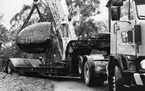 'Göteborgs Naturhistoriska museum november 1978: :: Maskinell lastning med lyftkran? av 30 ton tunga blocket av vindslipad ögongnejs, skänkt 1963. Transport med Gamlestadens lastbilar från södra gaveln till östra ytterväggen utanför nuvarande huvudentré. ::  :: Ingår i serie med fotonr. 5527:69-216.'