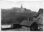 'Naturhistoriska museet i Slottsskogen, sett från Annedalskyrkan, under byggnadsarbetet. I förgrunden tågstationshuset till Säröbanan. Byggställningar. Baracker. ::  :: (Borde kanske vara 1923-04-11?)'