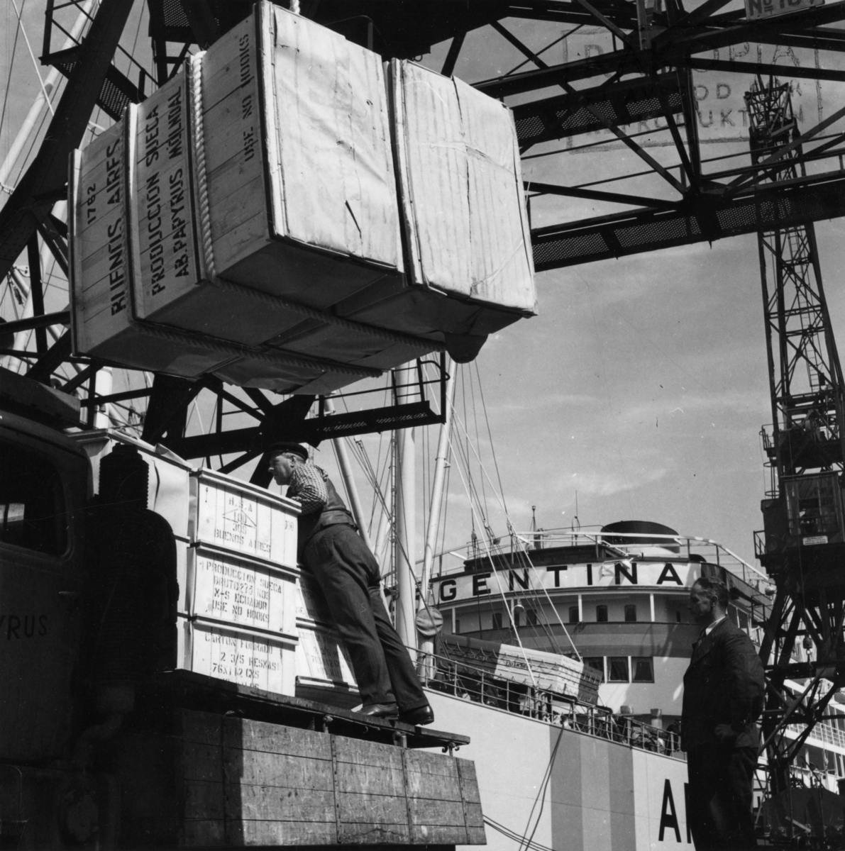Lastning vid Frihamnspiren i Göteborg. 

Fartyget på bilden är M/S Argentina II. Argentina byggdes på Götaverken 1943. Hon sjösattes 28 augusti 1942, samt gick på provtur och levererades sedan den 27 januari 1943. Gjorde under återstoden av kriget ett flertal lejdresor till Argentina och Brasilien. Svenska exportvaror ner, samt en rad livsnödvändiga produkter hem bl.a. spannmål. Tidvis mellan lejdresorna när hon väntade på utväxling låg hon upplagd i Göteborg. Befälhavare när hon gick ut på första resan var K. Andreasson samt Maskinchef var J. Elowsson. Denna fartygsserie som byggdes för Johnson (Nordstjernan) mellan 1935 och 1948 bestod av 21 fartyg. Sjutton av dom var byggda på Götaverken samt fyra av dom var utlagda för byggnation på Kockums. Det var systerfartyg alltså byggda på samma ritningar, men naturligtvis skedde en del smärre förändringar genom åren. Men rent utseendemässigt är det väldigt svårt för en amatör att se skillnad på fartygen. Men en sak som skiljer om man vet om det är placering och antal fönster (ventiler) på förkant promenaddäck, alltså däck nummer två. På Argentina I, den som byggdes 1935 och minsprängdes 1942, fanns det på förkanten här 16 fönster (ventiler), de gick ända ut till rundningen på sidan av bygget. Medan däremot Argentina II (den på bilden) som byggdes 1943 endast hade 12 fönster (ventiler) på förkant detta däck, och de gick inte heller hela vägen ut till rundningen (sidan). 

När det gäller M/S Argentina I, detta fartygsnamne, kommer här en redogörelse för dess öde. Den sista resan anträdes 3 april 1942. Destinationen för resan var Buenos Aires i Argentina, I lasten ingick bland annat papper från AB Papyrus.

M/S Argentina I gick i lejdetrafik under Andra Världskriget och resan till Buenos Aires gjordes i sällskap med bolagsfartyget Annie Johnson. Från Buenos Aires gick man senare vidare till Santos i Brasilien.

15 juli 1942 lämnade man Santos i följe med Svenska Amerika Mexiko Liniens M/S Uddeholm.  Den 6 juli körde de två fartygen på en tysk minspärr 30 sjömil sydväst om Kristiansand. Först gick Uddeholm på. Där klarade sig hela besättningen. Därefter var det M/S Argentinas tur. Detta fartyg sjönk på två minuter. Fyra man omkom varav två ur besättningen, en kontrollofficer och en passagerare.