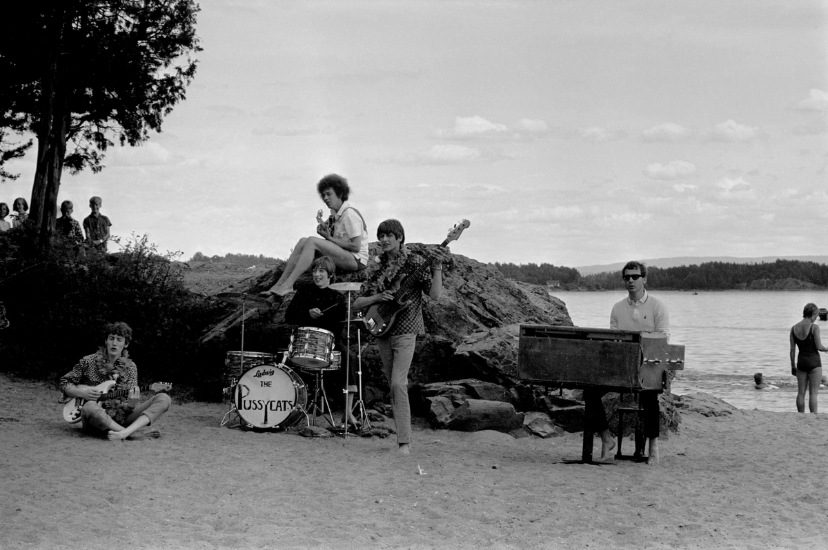 Popgruppa The Pussycats spiller på Hvalstrand i forbindelse med TV-programmet Op-erasjon Hvalstrand. Fra venstre gitarist Trond Graff (sittende), gitarist Ottar Aasegg (sittende på svaberg), trommer Friedel Brandt vokalist og bassist Sverre Kjelsberg og organist Ingemar Stjerndahl.