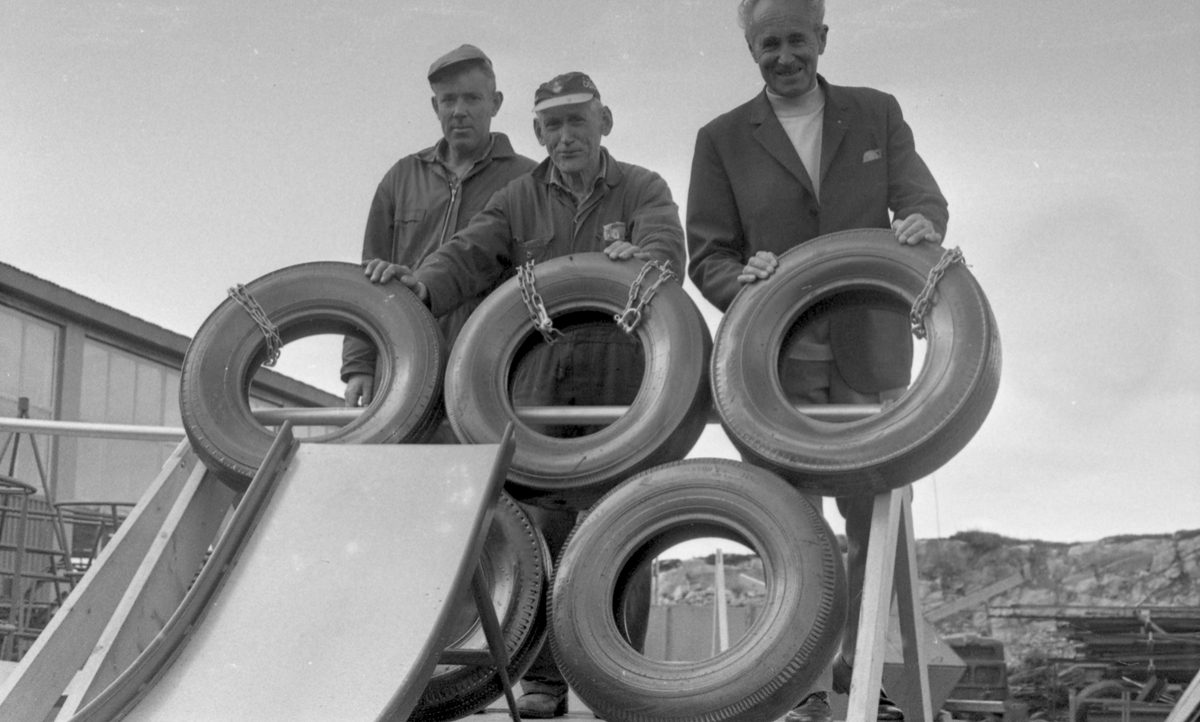Produsenten viser fram årets produksjon av lekeapparater. Direktøren står stolt sammen med noen av sine arbeidere.