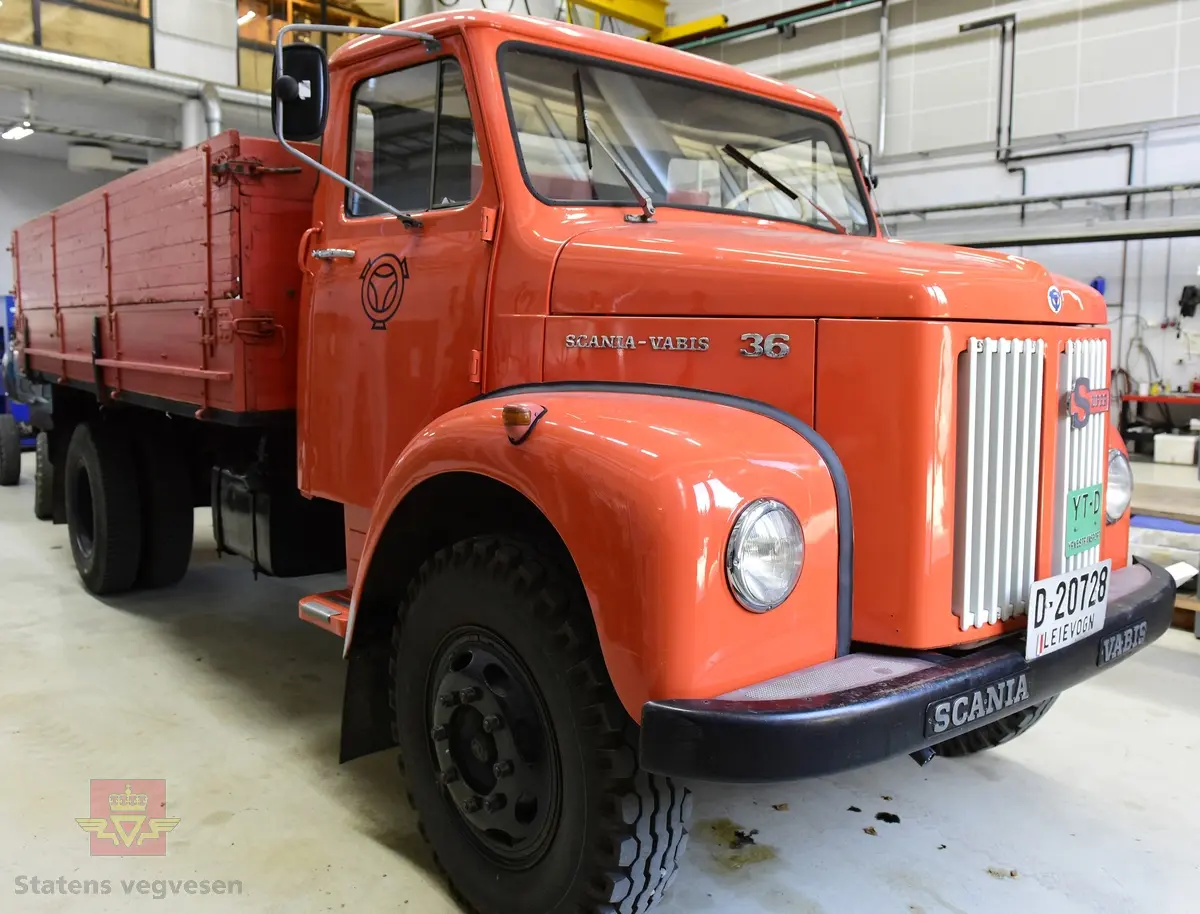 Lastebil på 6 hjul, (to akslet) med bakhjuls drift. Akselavstand 4,2 meter.  I hovedsak oransje. Motoren er en turbomatet 4-sylindret dieselmotor av typen Scania-Vabis DS5, den yter 120 hestekrefter og har et sylindervolum på 5193 kubikkcentimeter. Girkassen er en manuell 5-trinns synkronisert utgave, høy- og lavgir i bakakslingen (two-speed) gir tilsammen 10 gir pluss revers. Bremsene er drevet av trykkluft. Bilen har lasteplan med karmer og et ekstra sett karmer på toppen. Bilen har 3-veis hydraulisk tipp fra Thanstrøm i Halden. Svart interiør, lakkert grå innvendig. Egenvekten er ca. 5,1 tonn, lasteevne ca. 5,825 tonn. Totalvekt 11 tonn.
Farge: paprika rød.