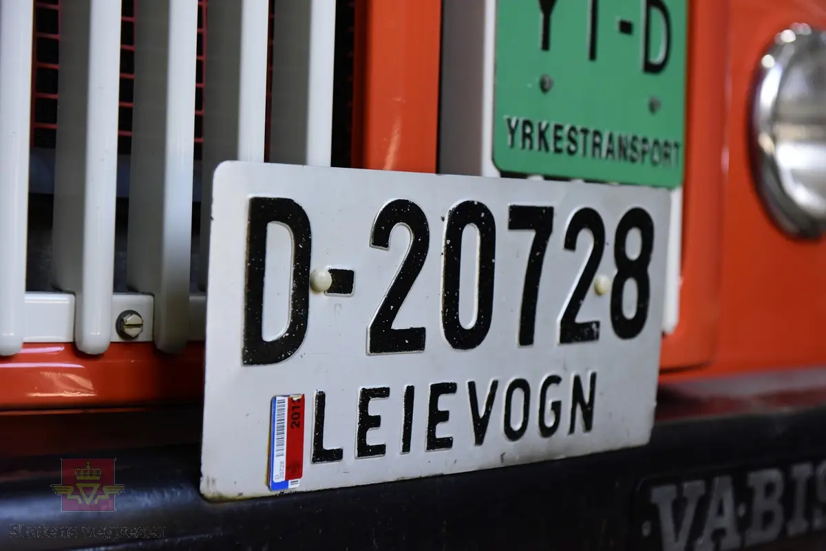 Lastebil på 6 hjul, (to akslet) med bakhjuls drift. Akselavstand 4,2 meter.  I hovedsak oransje. Motoren er en turbomatet 4-sylindret dieselmotor av typen Scania-Vabis DS5, den yter 120 hestekrefter og har et sylindervolum på 5193 kubikkcentimeter. Girkassen er en manuell 5-trinns synkronisert utgave, høy- og lavgir i bakakslingen (two-speed) gir tilsammen 10 gir pluss revers. Bremsene er drevet av trykkluft. Bilen har lasteplan med karmer og et ekstra sett karmer på toppen. Bilen har 3-veis hydraulisk tipp fra Thanstrøm i Halden. Svart interiør, lakkert grå innvendig. Egenvekten er ca. 5,1 tonn, lasteevne ca. 5,825 tonn. Totalvekt 11 tonn.
Farge: paprika rød.