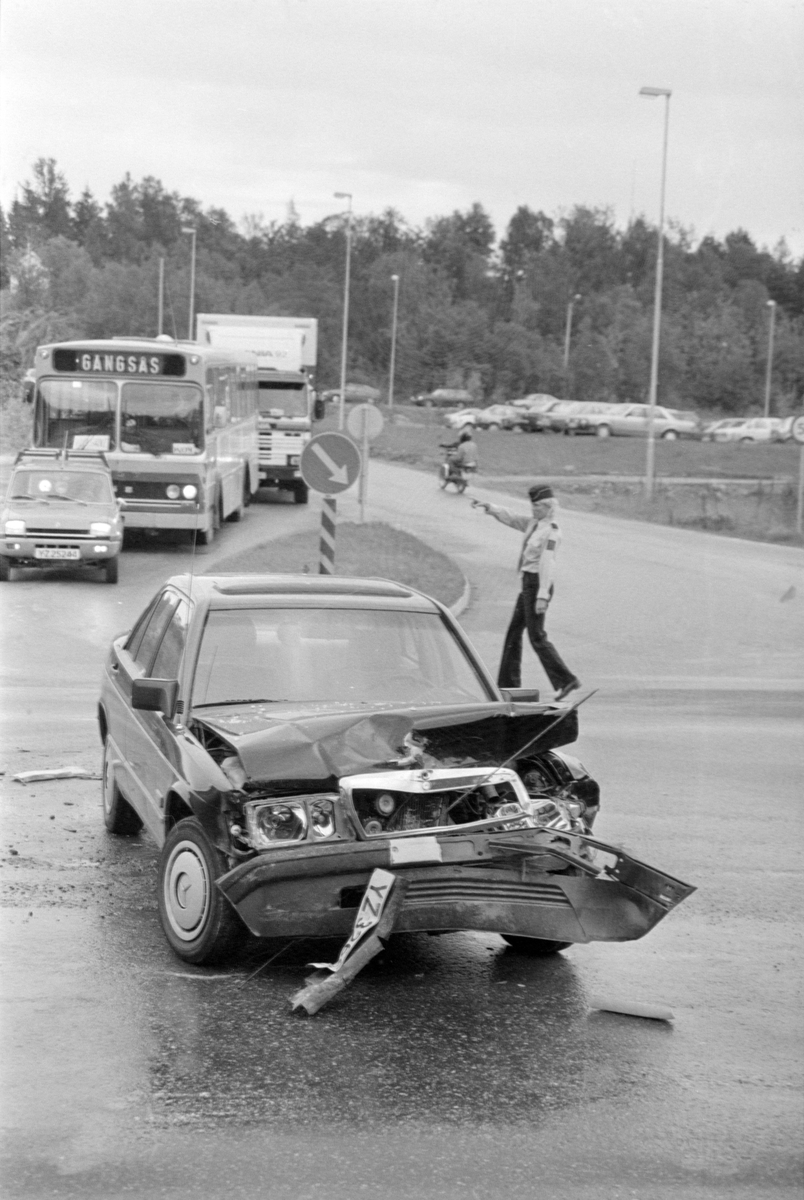 Ødelagt bil i Kanebogenkrysset. Politibetjent Tone Didriksen dirigerer traffikk i bakgrunnen.