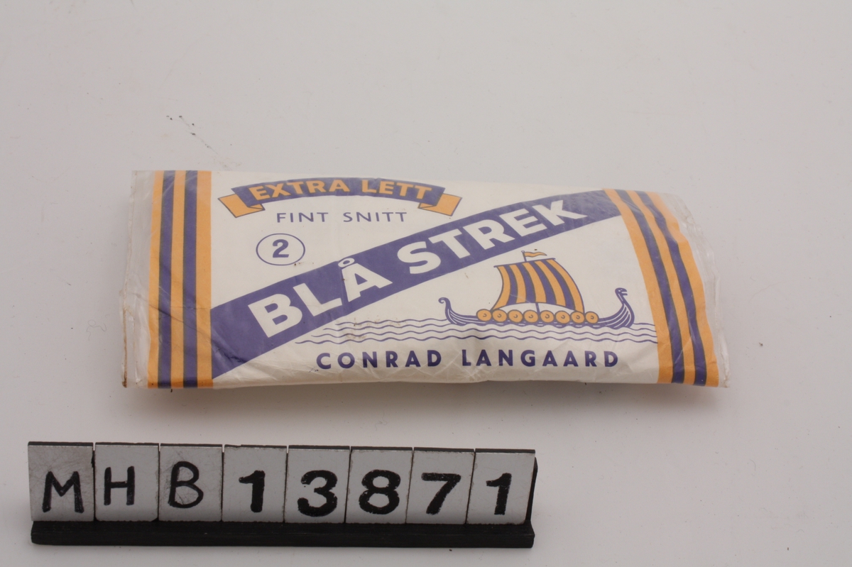 Emballasje for rulletobakk med rektangulær form. Den består av plastbelagt papir som danner en beholder for tobakk med lokk over.