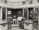 Utställningen för Konsthantverk och Konstindustri, Stockholm, 1909. Svensk Hemslöjds utställning, Norrbottens län. Samisk slöjd. Maria Persson sitter i utställningen.