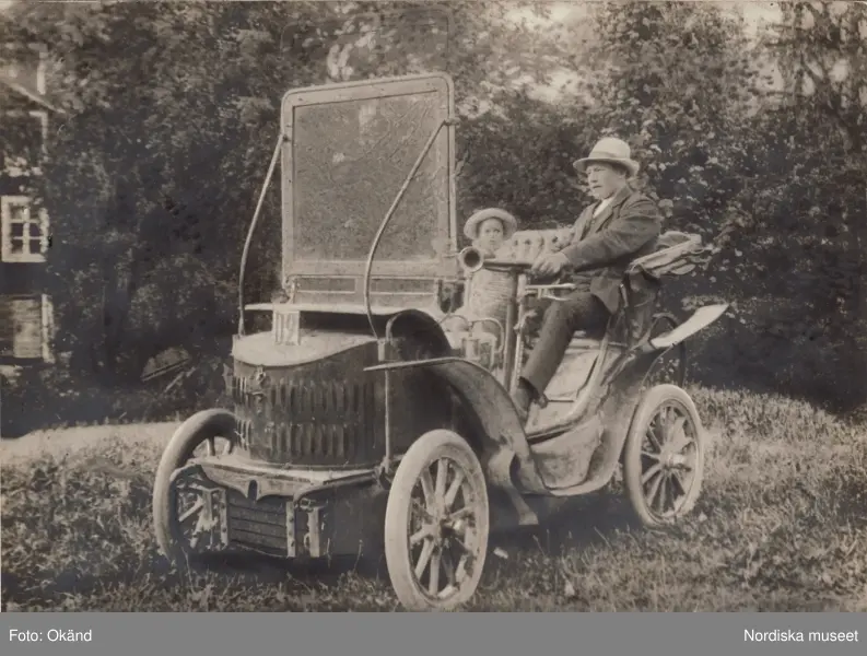 General Motors. "Baksidestext i svag blyerts: Grosshanl. Evald Lönnberg sommaren 1909 i hans första automobil "Maurer Union", 5 hkr. Ludwig Maurer i Nürnberg bedrev automobiltillverkning före första världskriget. Ett fordon väldigt likt detta finns i Schlumpfsamlingen i Mulhouse i Frankrike. Den är daterad 1901, så bilen på bilden var troligen ett antal år gammal 1909. Den hade kraftöverföring via friktionsskiva. Registreringsnumret D2 antyder att platsen är någonstans i Södermanland."