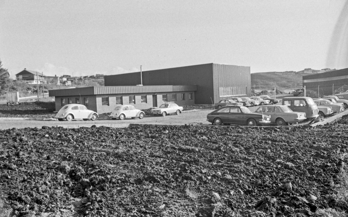 Statens Vegvesen. Murbygning. Parkerte biler. Åpent landskap.