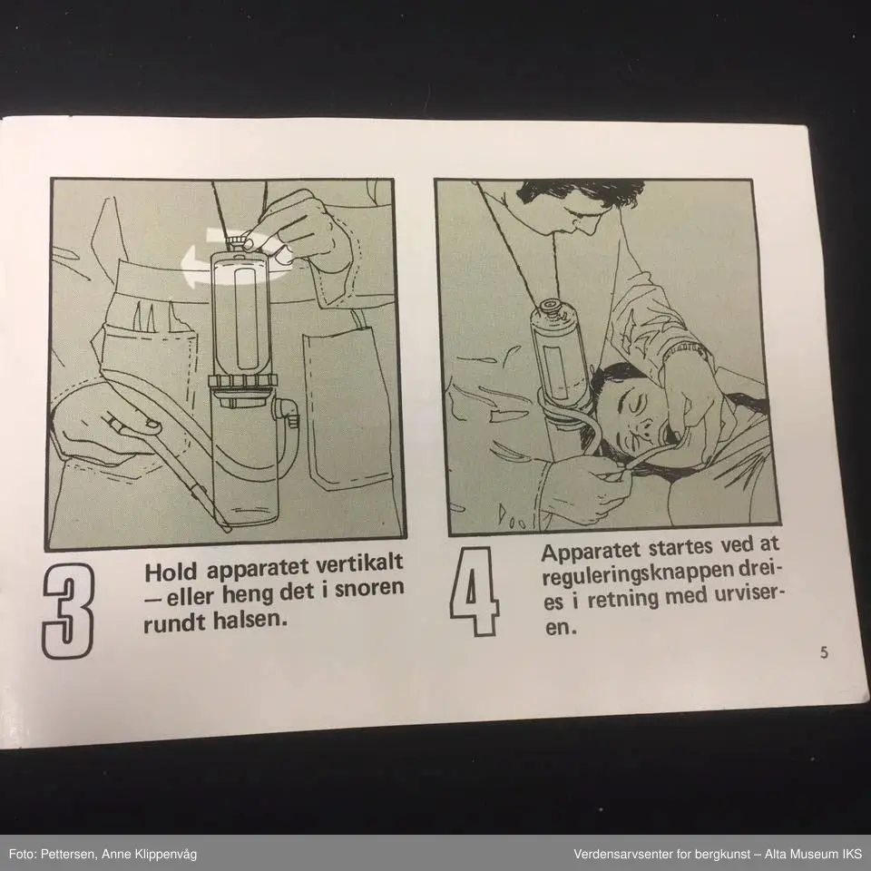 A. Sylinderformet plastapparat med tilfestet gummislange og gjennomsiktig plasttut.  Inneholder en driftspatron fylt med ufarlig gass.
B Rektangulært hefte, bruksanvisning.