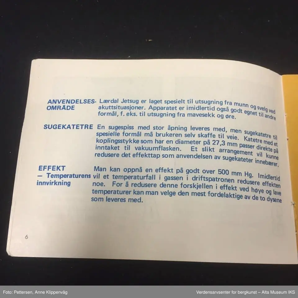 A. Sylinderformet plastapparat med tilfestet gummislange og gjennomsiktig plasttut.  Inneholder en driftspatron fylt med ufarlig gass.
B Rektangulært hefte, bruksanvisning.