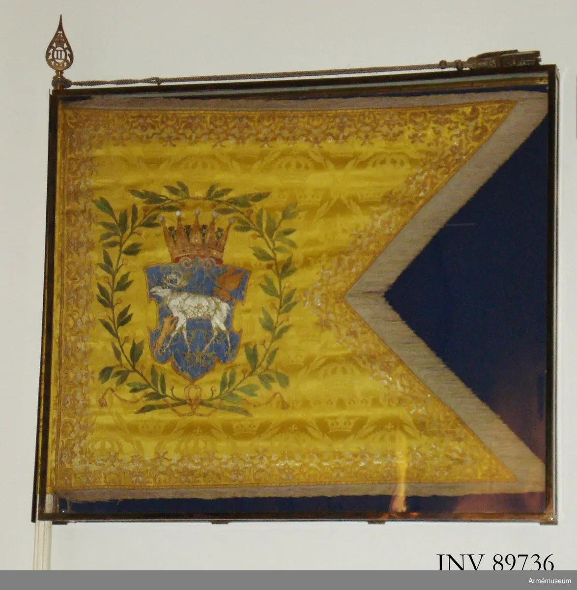 Duk av gul damast, tvåtungad med frans. Jämtlands vapenbild under hertigkrona omgiven av lagerkrans. Motivet målat. Bård runt duken broderad med guldtråd. Tillhörande kordong.