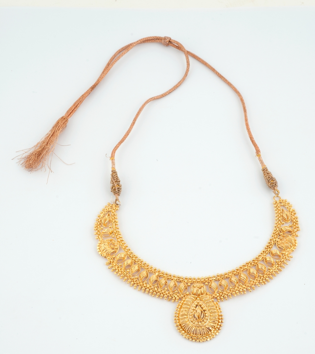 Gullfargede smykker til brudedrakt. Består av 9 armringer, et par øreheng, 2 halssmykker og 2 anheng = ukjent bruk