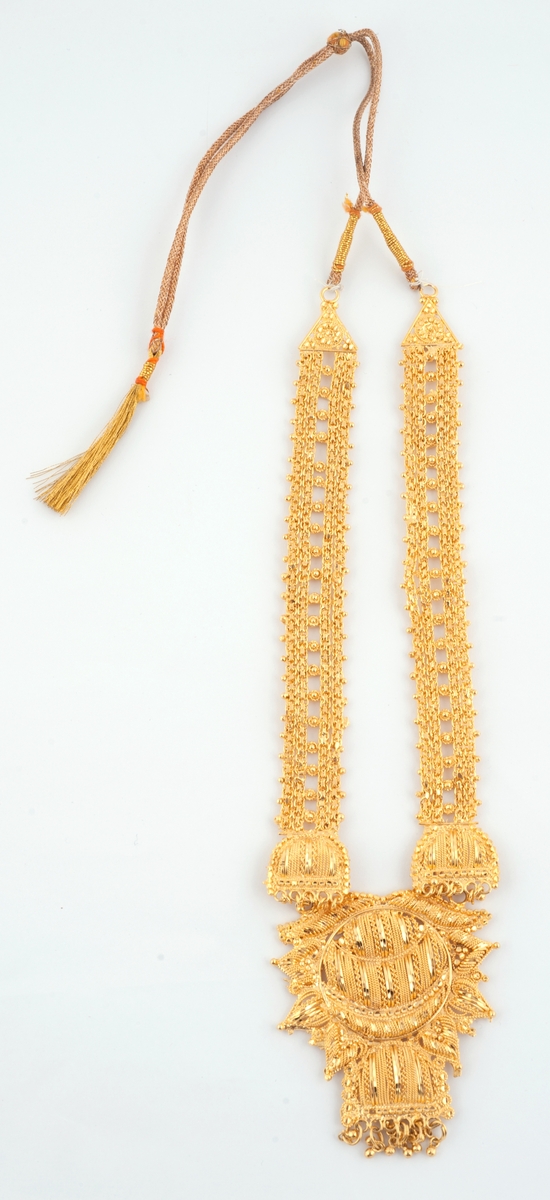 Gullfargede smykker til brudedrakt. Består av 9 armringer, et par øreheng, 2 halssmykker og 2 anheng = ukjent bruk