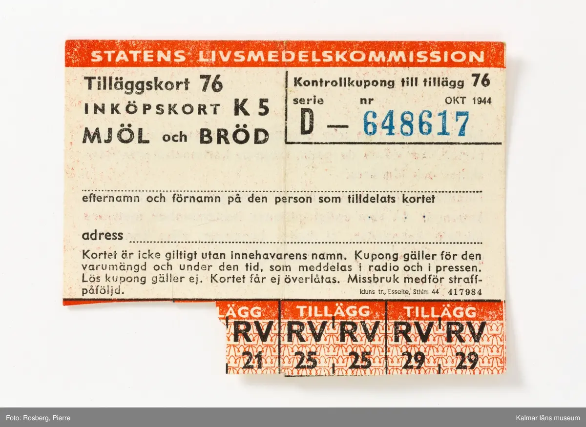 KLM 28613:9 Ransoneringskort i fodral, av papp, ytskikt i läderimitation, brun med grön knapp för knäppning. Indelad i flera avskilda fack för olika typer av ransoneringskort, Växl.-kort Bröd; Växl.-kort Kött; Växl.-kort Matfett; Samlingskort Socker, Bröd, Matfett; Kött; Beredskapskort; Kaffe; Kläder; Tvätt; Ägg. I fodralet ligger omkring 180 kort av alla de slag. Datering, 1940-1945. Tillverkade av Statens livsmedelskommission.
I mappen ligger även ett tidningsurklipp med ransoneringsschema, med villkor för hur inköpskorten fungerade, klippt ur Stockholms-Tidningen, publicerat den 20 juni 1943.