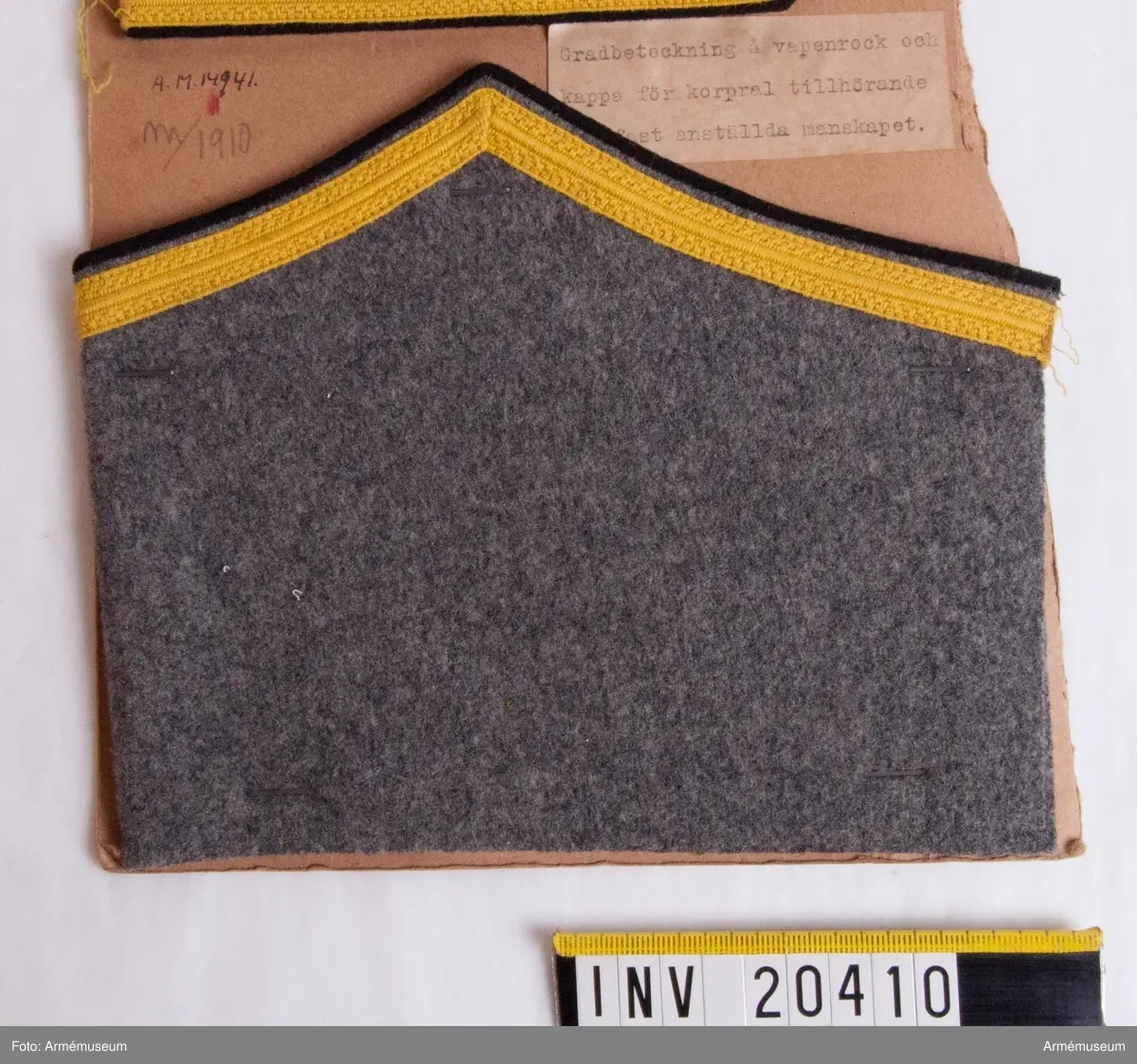 Grupp C I.
Med gradbeteckning för korpral tillhörande fast anställt manskap. För vapenrock och kappa.