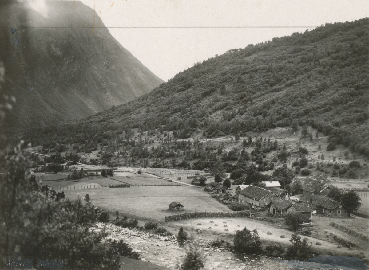 Prospektfotografi av gården Jøsvold i Stordal. Gårdstunet med marker og hesjer rundt.