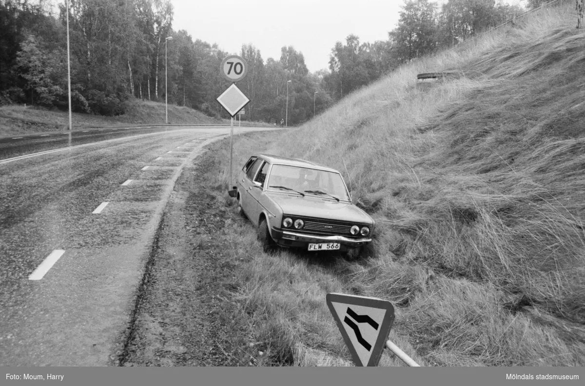 Bil som kört i diket vid Östra Lindomevägen i Kållered, år 1983. "Här var det avsmalnande väg. Så det gäller att se sig för."

För mer information om bilden se under tilläggsinformation.