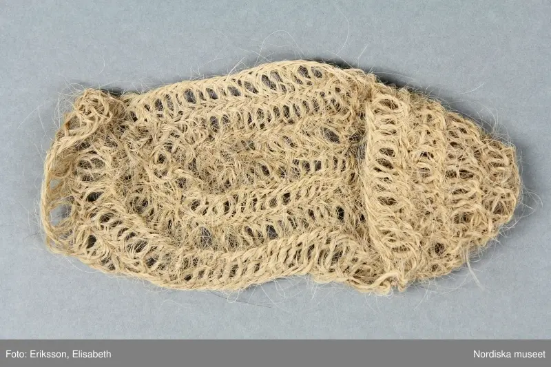 A-B. Tagelsocka för kvinna, ett par.
Nålbindning i stora glesa maskor med spunnet kosvanstagel.
/Berit Eldvik 2002
